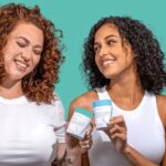 Two women holding Happy V wellness products in a bright lifestyle scene