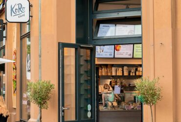 KoRo Café mit sichtbarem Eingang und urbaner Alltagsszene