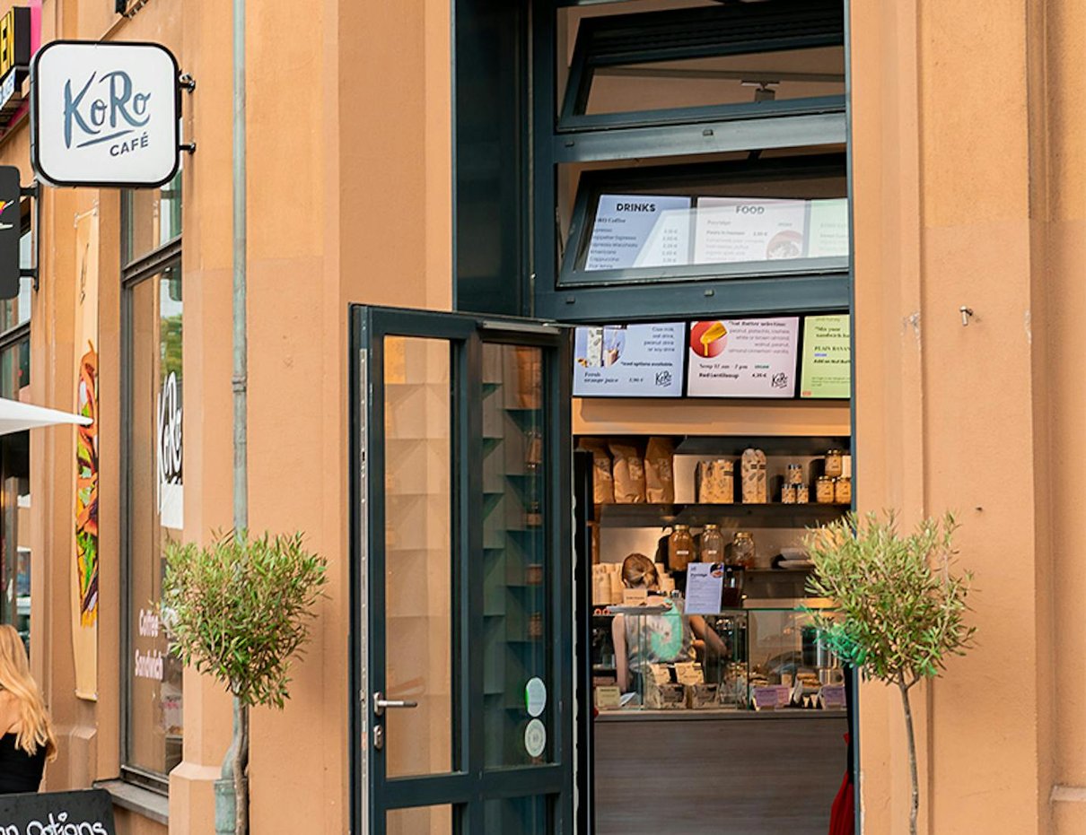 KoRo Café mit sichtbarem Eingang und urbaner Alltagsszene