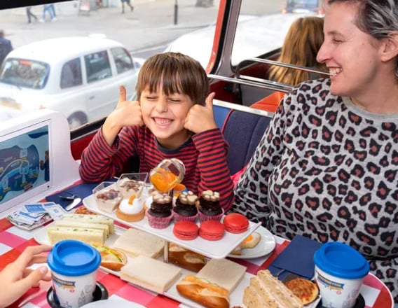 Family enjoying Paddington afternoon tea on a London sightseeing bus