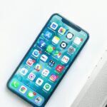 iPhone on a desk beside a laptop