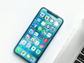 iPhone on a desk beside a laptop