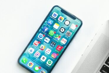 iPhone on a desk beside a laptop