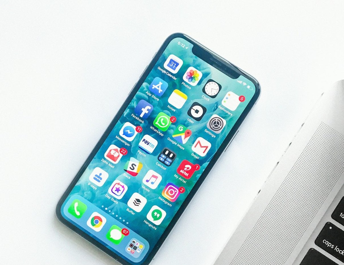 iPhone on a desk beside a laptop