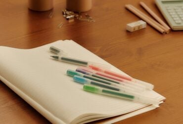 MUJI stationery arranged on a wooden desk