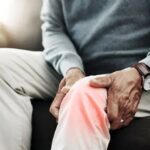 Person using red light therapy for joint comfort at home
