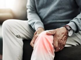 Person using red light therapy for joint comfort at home