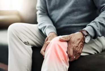 Person using red light therapy for joint comfort at home