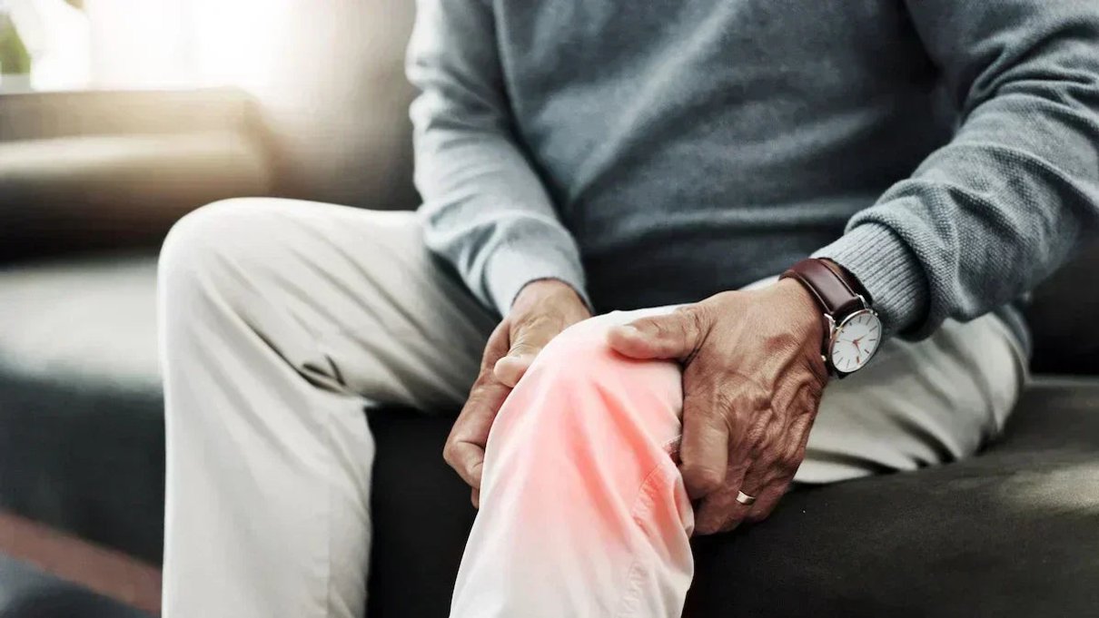 Person using red light therapy for joint comfort at home