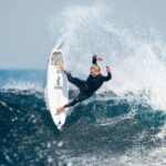 Surfer carving a turn on a wave in a Billabong surf campaign
