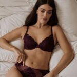 Modelka w bordowej bieliźnie Esotiq na łóżku