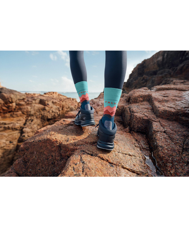 Wandelsokken zichtbaar in schoenen op een rotsachtig pad