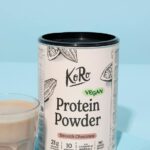 Packung Vegan Protein Powder Smooth Chocolate von Korodrogerie neben einem Glas