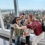 Family taking a selfie with New York City visible from the observatory