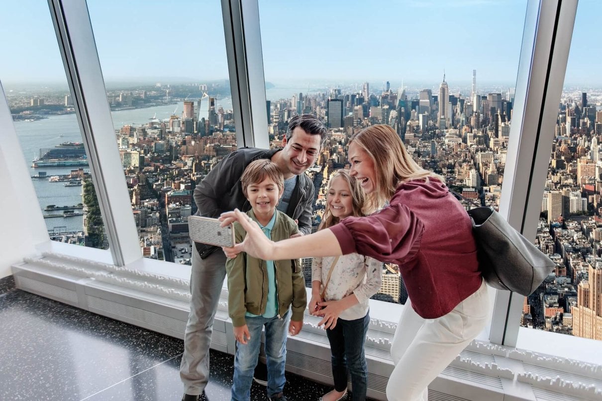 Family taking a selfie with New York City visible from the observatory