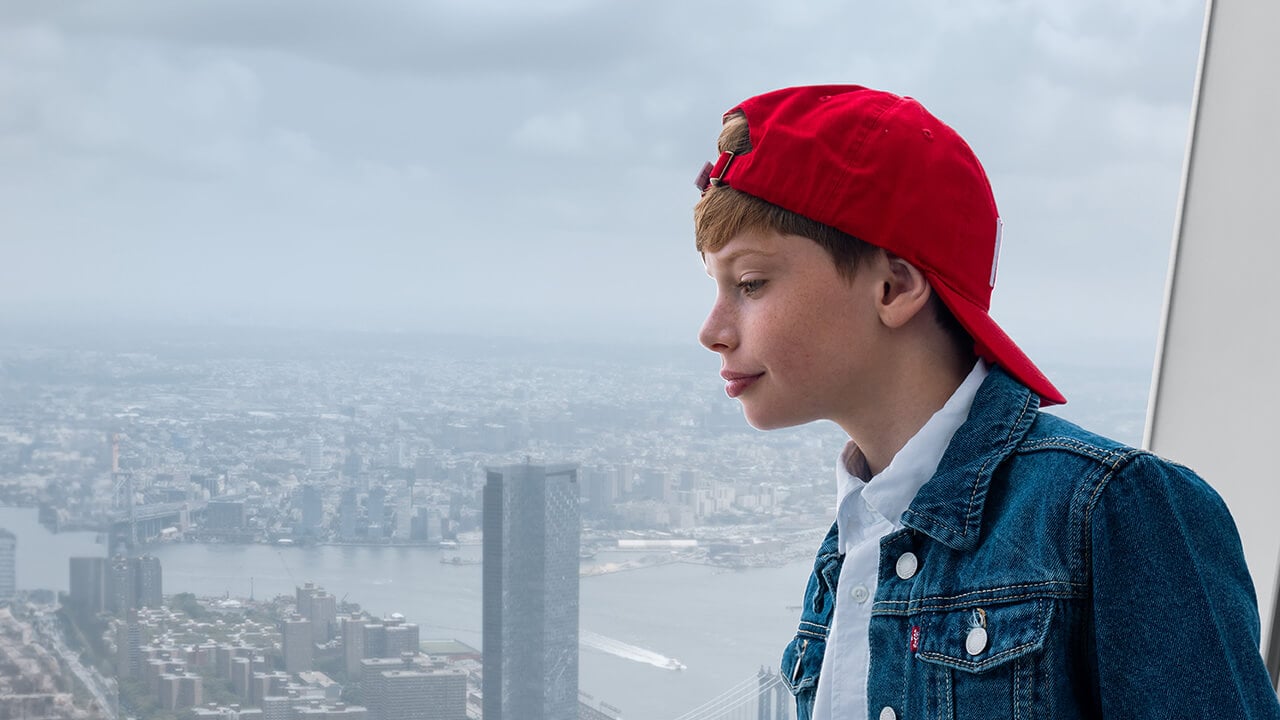 A young visitor taking in the panoramic view of Lower Manhattan