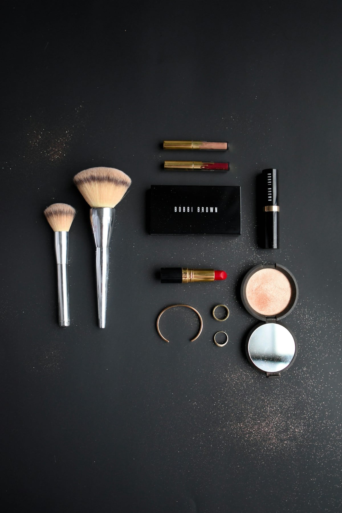 Makeup items arranged on a dark table