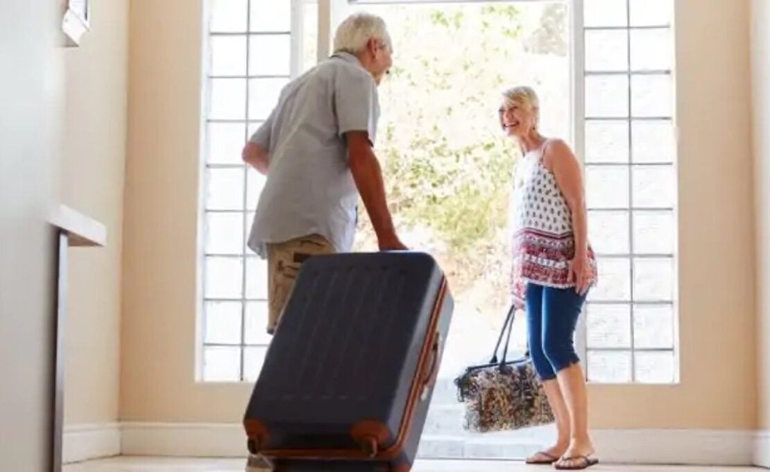 Older couple setting off with suitcases for a holiday