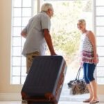 Older couple setting off with suitcases for a holiday