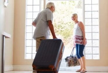 Older couple setting off with suitcases for a holiday