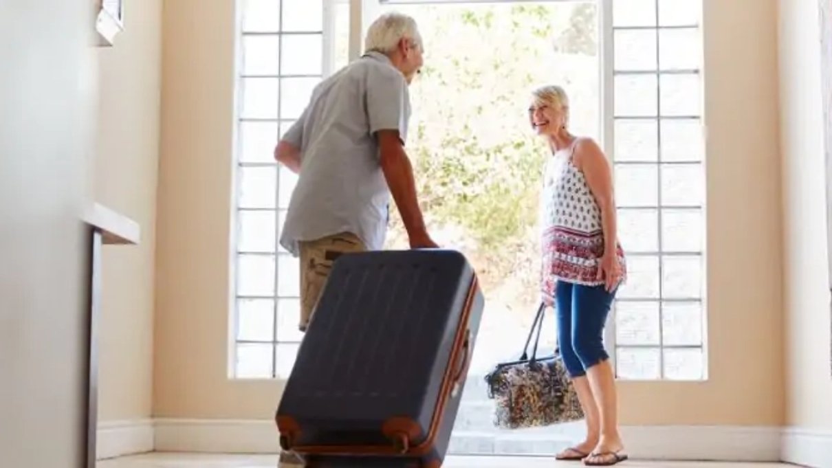 Older couple setting off with suitcases for a holiday