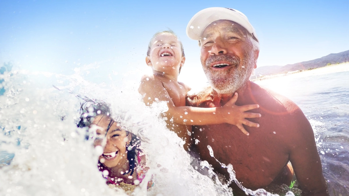 Grandparent swimming in the sea with children