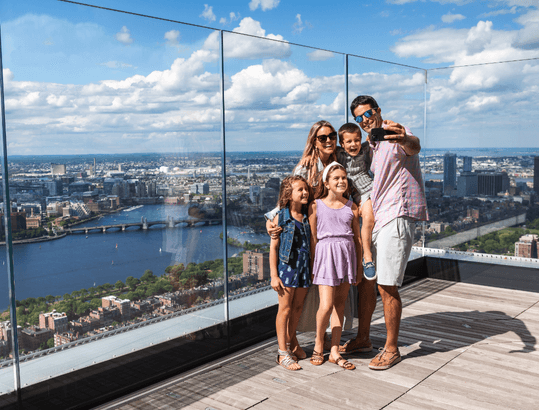 Family posing on the View Boston rooftop deck