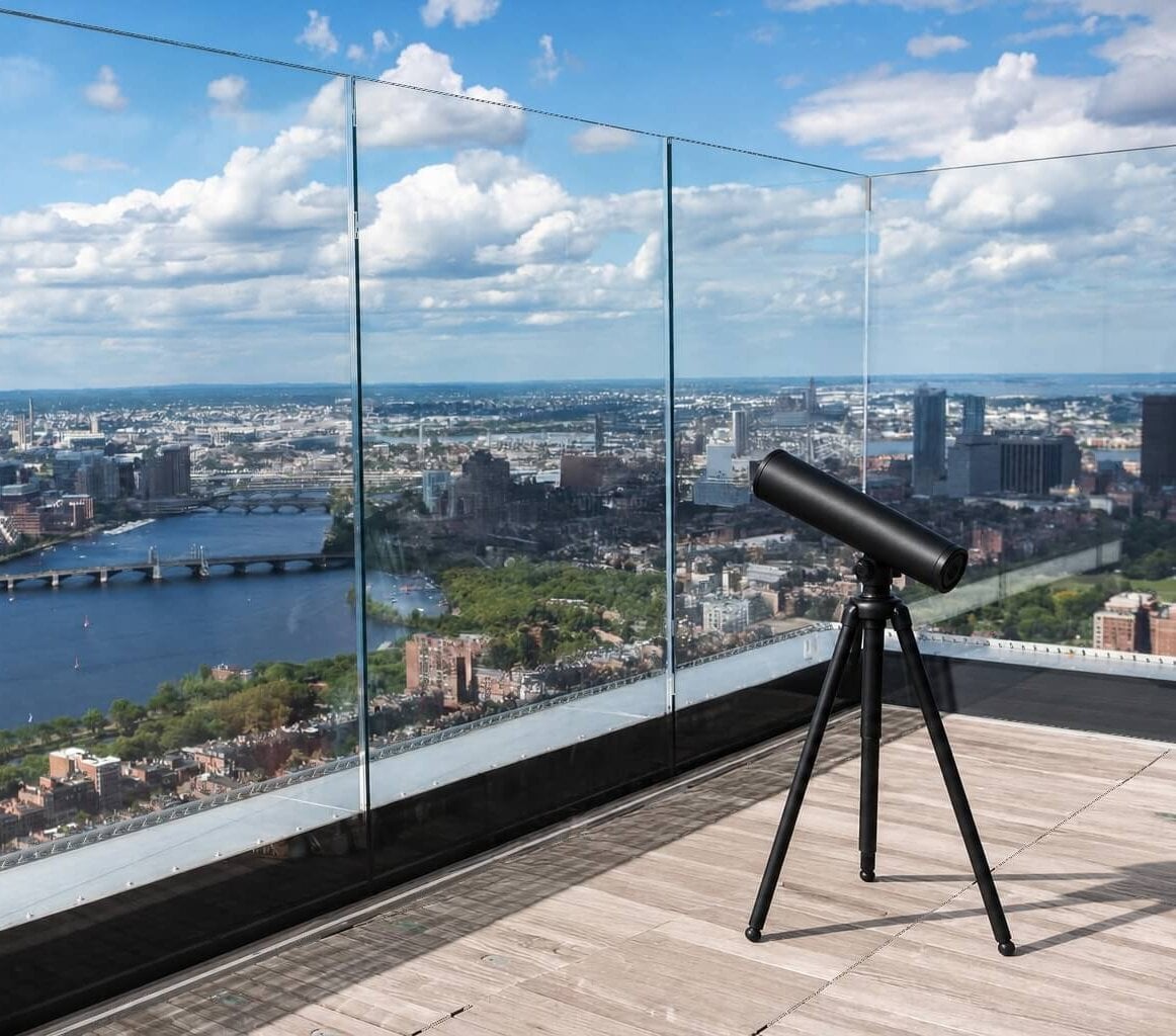 A visitor looking across Boston from an indoor observation area
