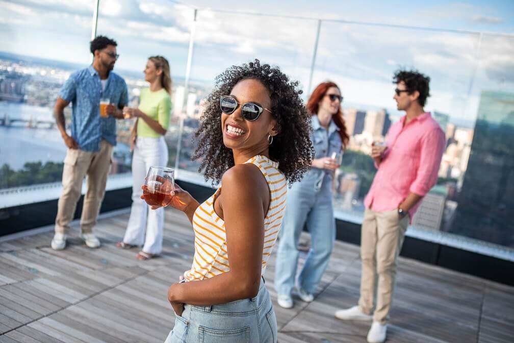 Visitors looking across Boston from View Boston outdoor roof deck