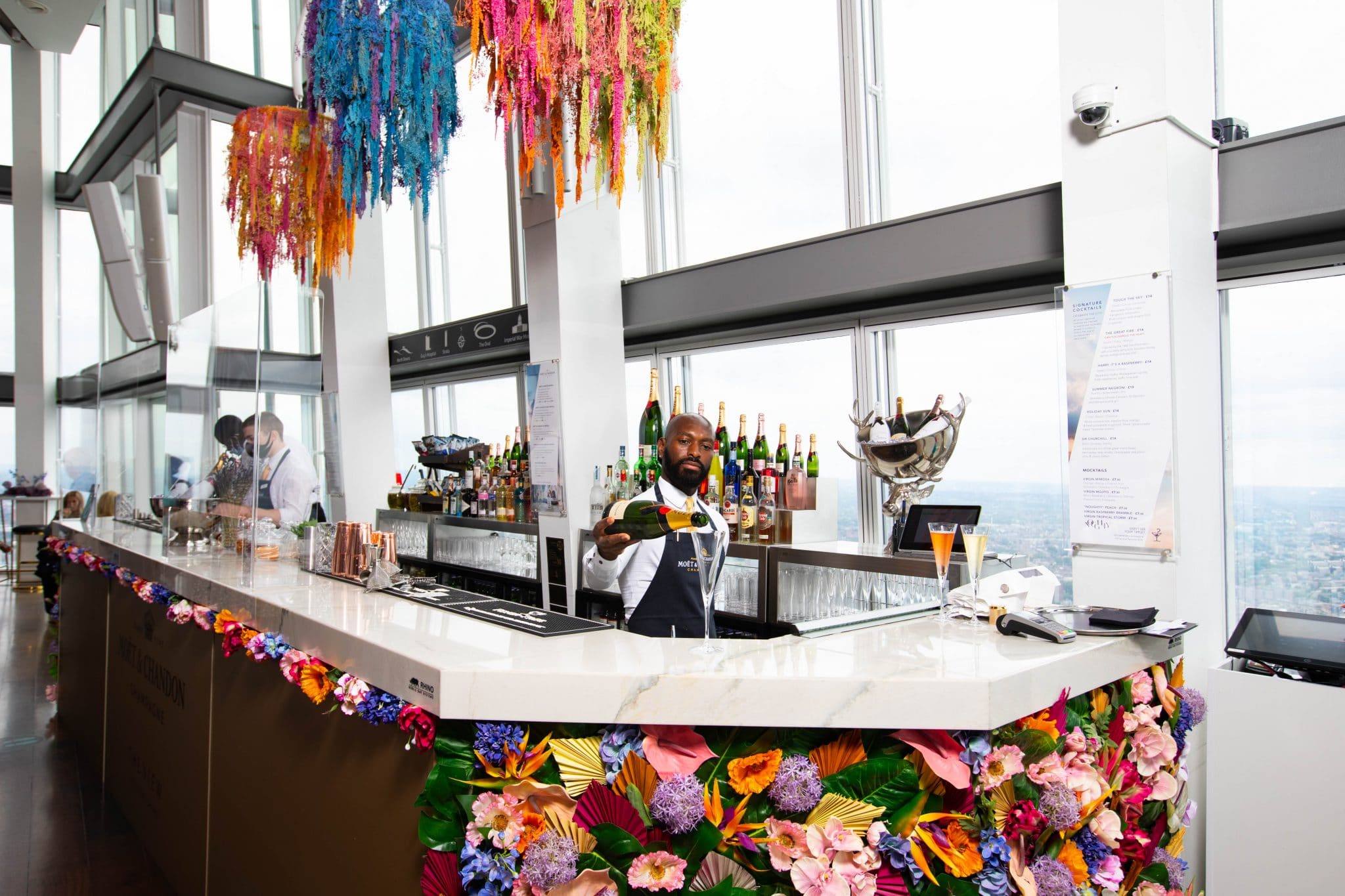 Bar staff serving guests among colourful floral displays at The View from The Shard