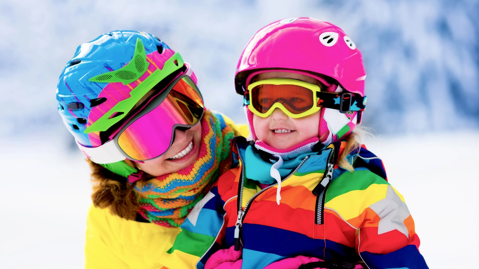 Two skiers smiling outdoors in a snowy setting